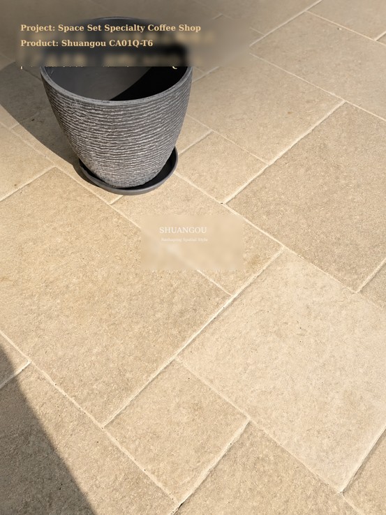 Close-up of Shuangou Limestone Castle Tile (Product No. CA01Q-T6) in soft light beige used for specialty coffee shop flooring with a potted plant.
