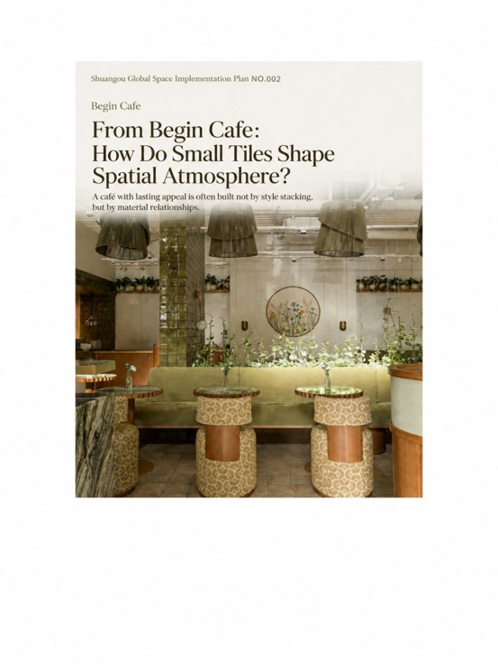 Begin Cafe interior poster showcasing olive-green tile-wrapped columns, soft green velvet booth seating, botanical wall art, and warm ambient lighting.